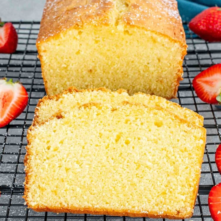 sliced butter cake on a black cooling rack.