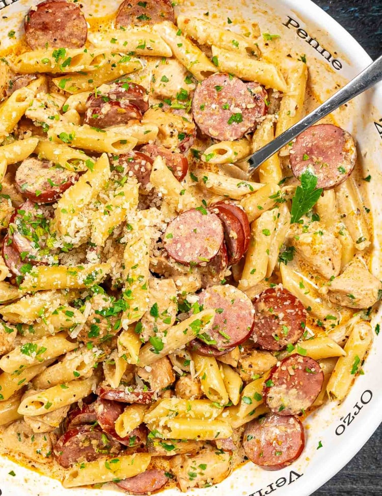 cajun chicken pasta garnished with parsley in a white bowl.