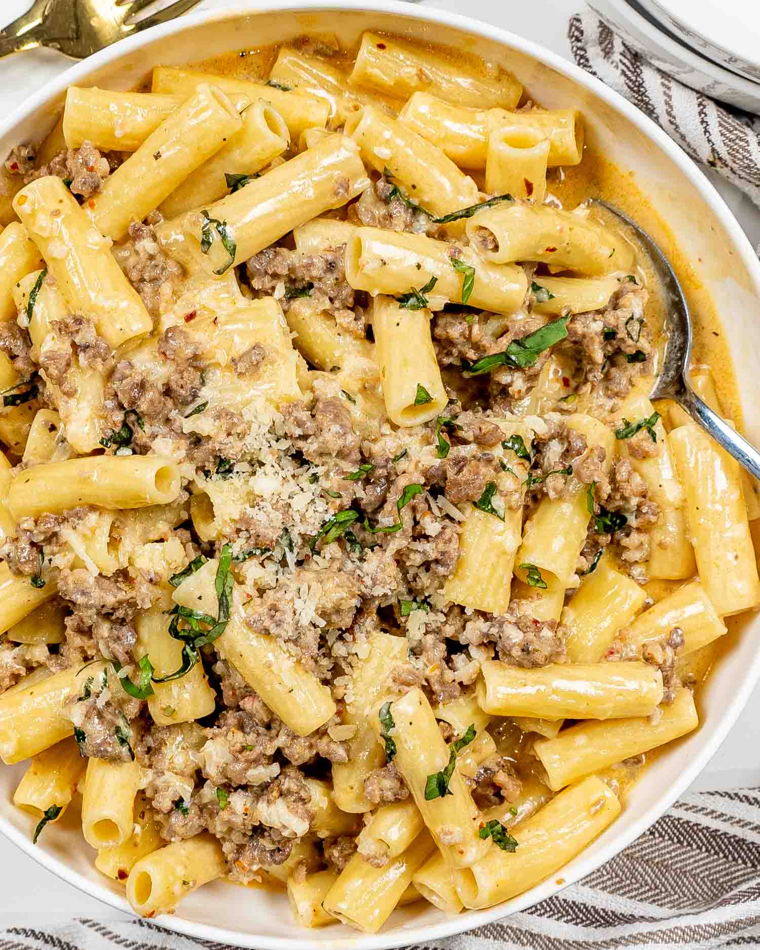 creamy italian sausage pasta in a white serving bowl.