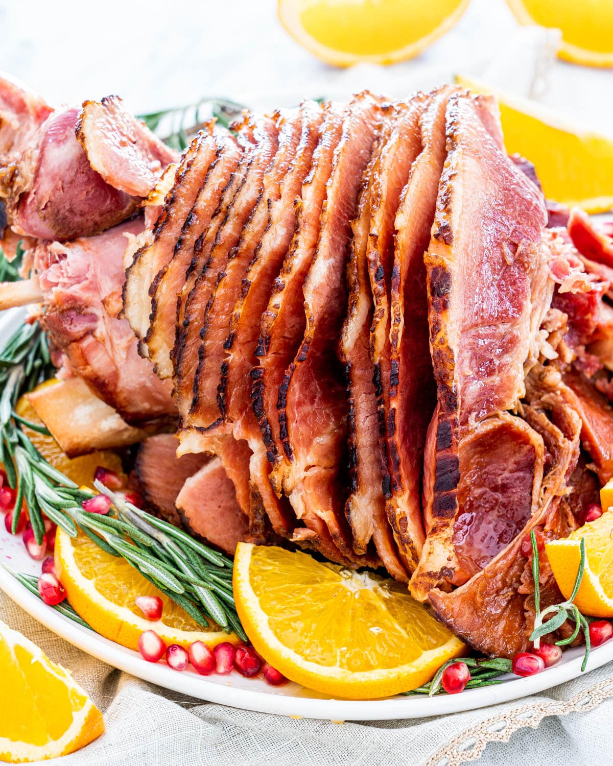 ham on a plater garnished with oranges and pomegranates seeds