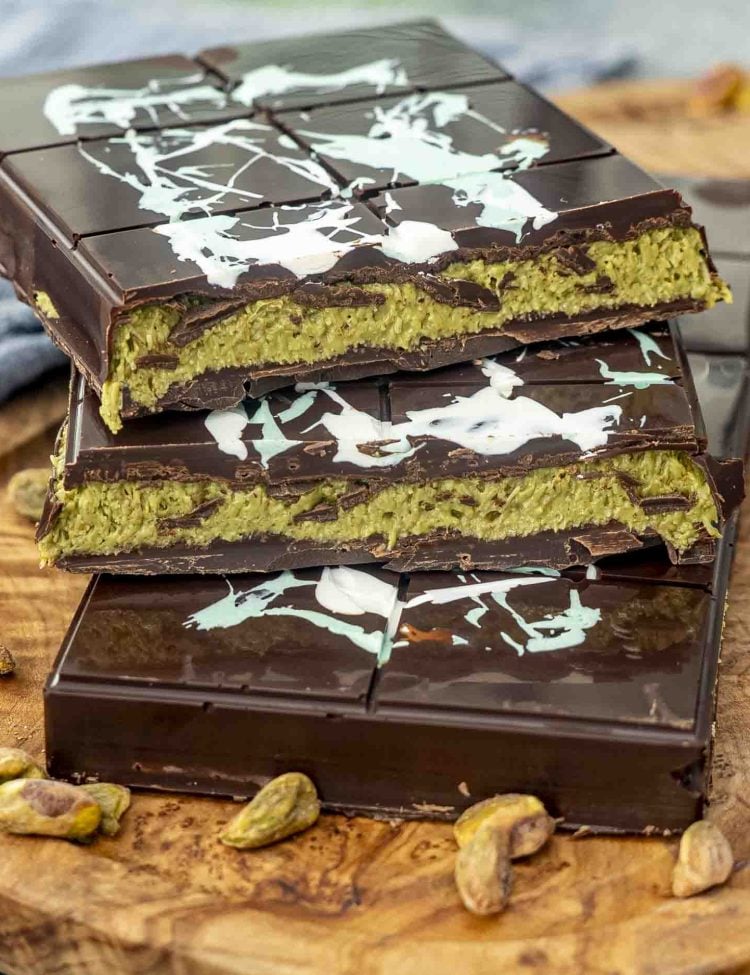 2 viral dubai chocolates on a cutting board with one cut in half so you can see the inside of it.