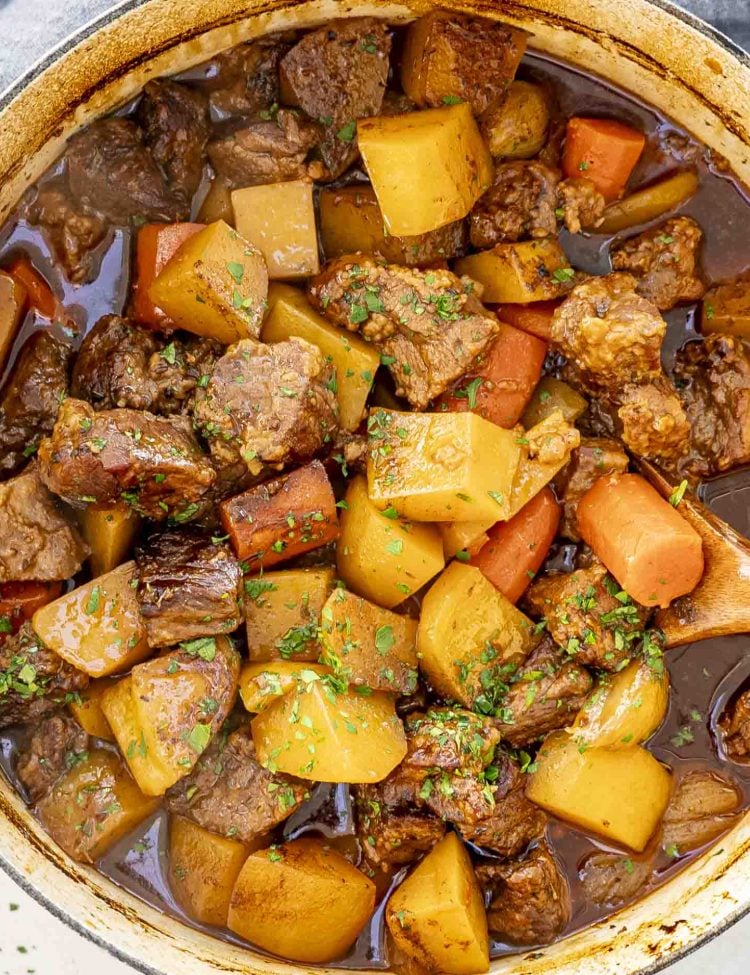 freshly made irish lamb stew in a dutch oven garnished with parsley.
