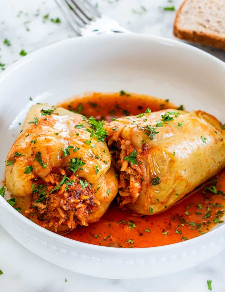 side view shot of two italian stuffed peppers in a bowl