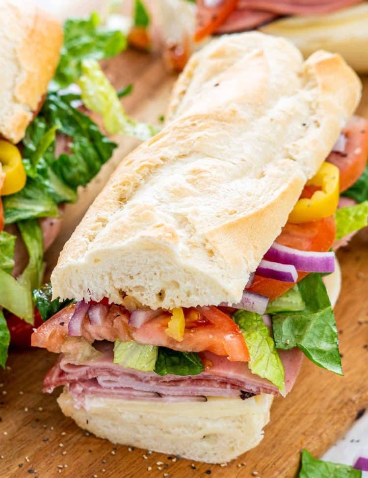closeup of a freshly made italian sub on a cutting board.