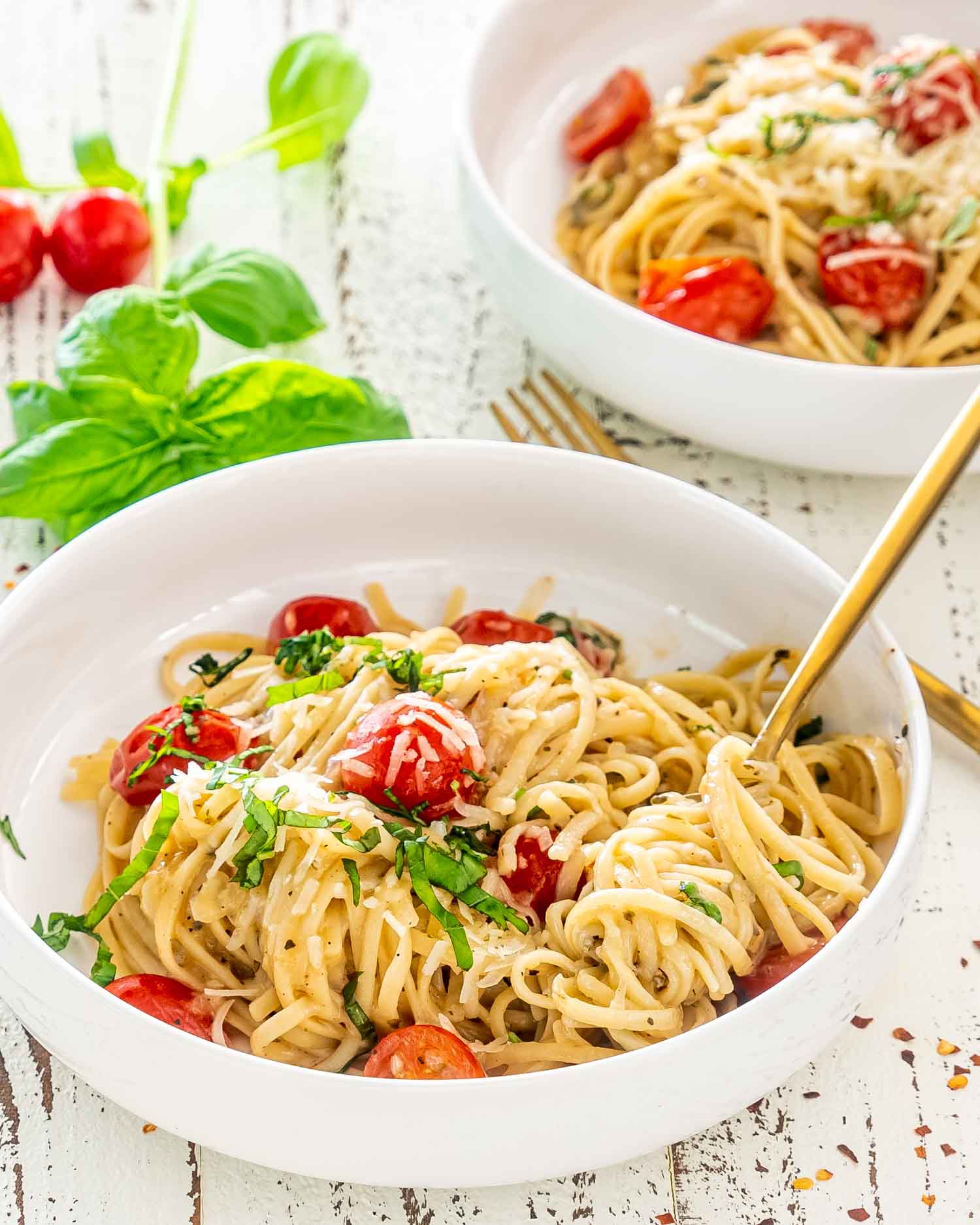 freshly made one pot pasta in white bowls garnished with basil.