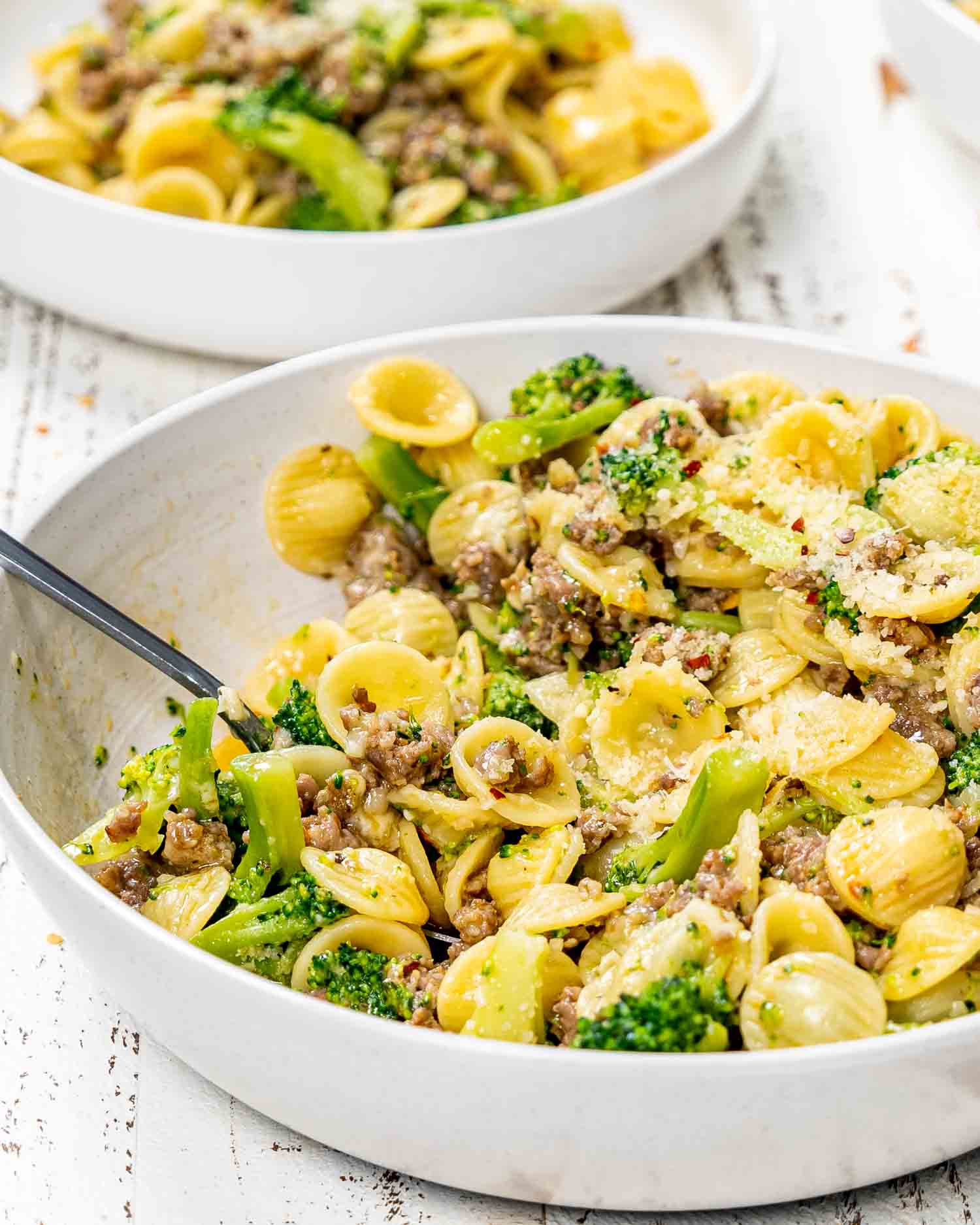 orecchiette with sausage and broccoli in a white serving bowl.