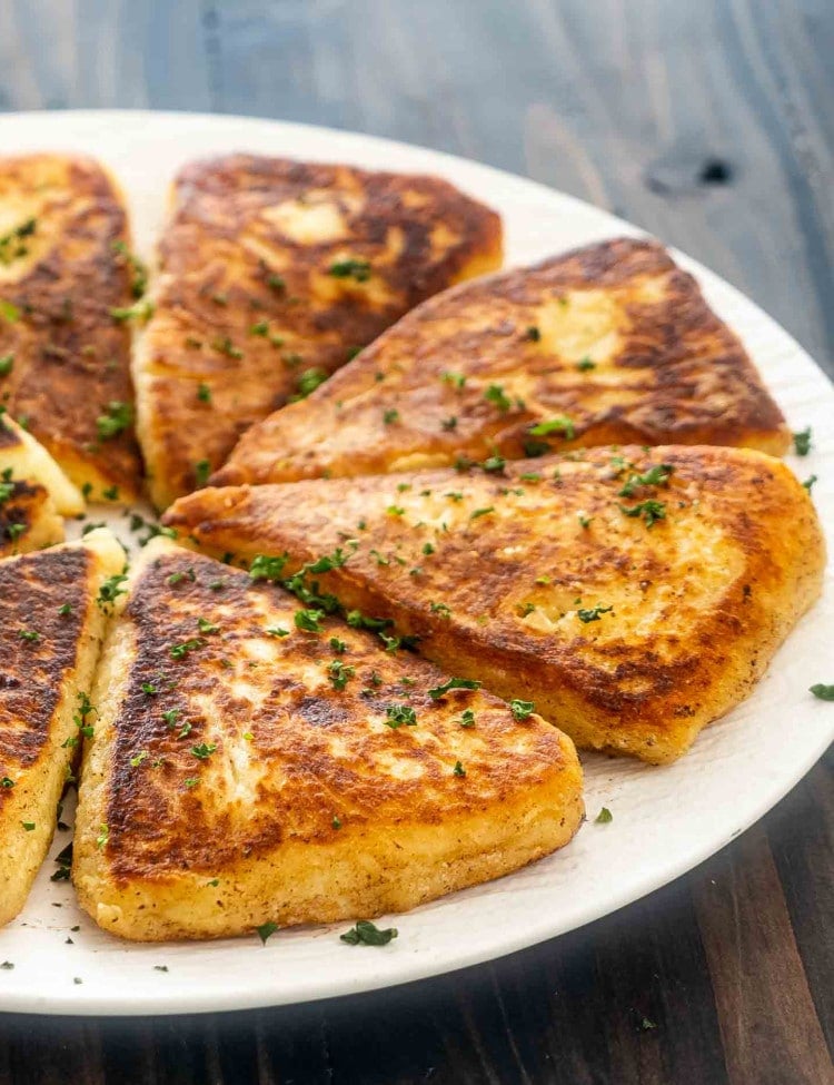 freshly fried irish potato cakes (potato farls) on a white plate.