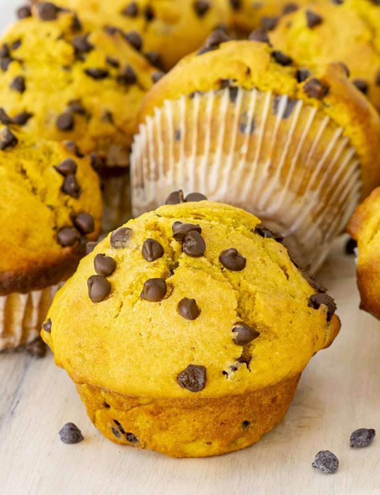 a closeup of pumpkin chocolate chip muffins on a cutting board.