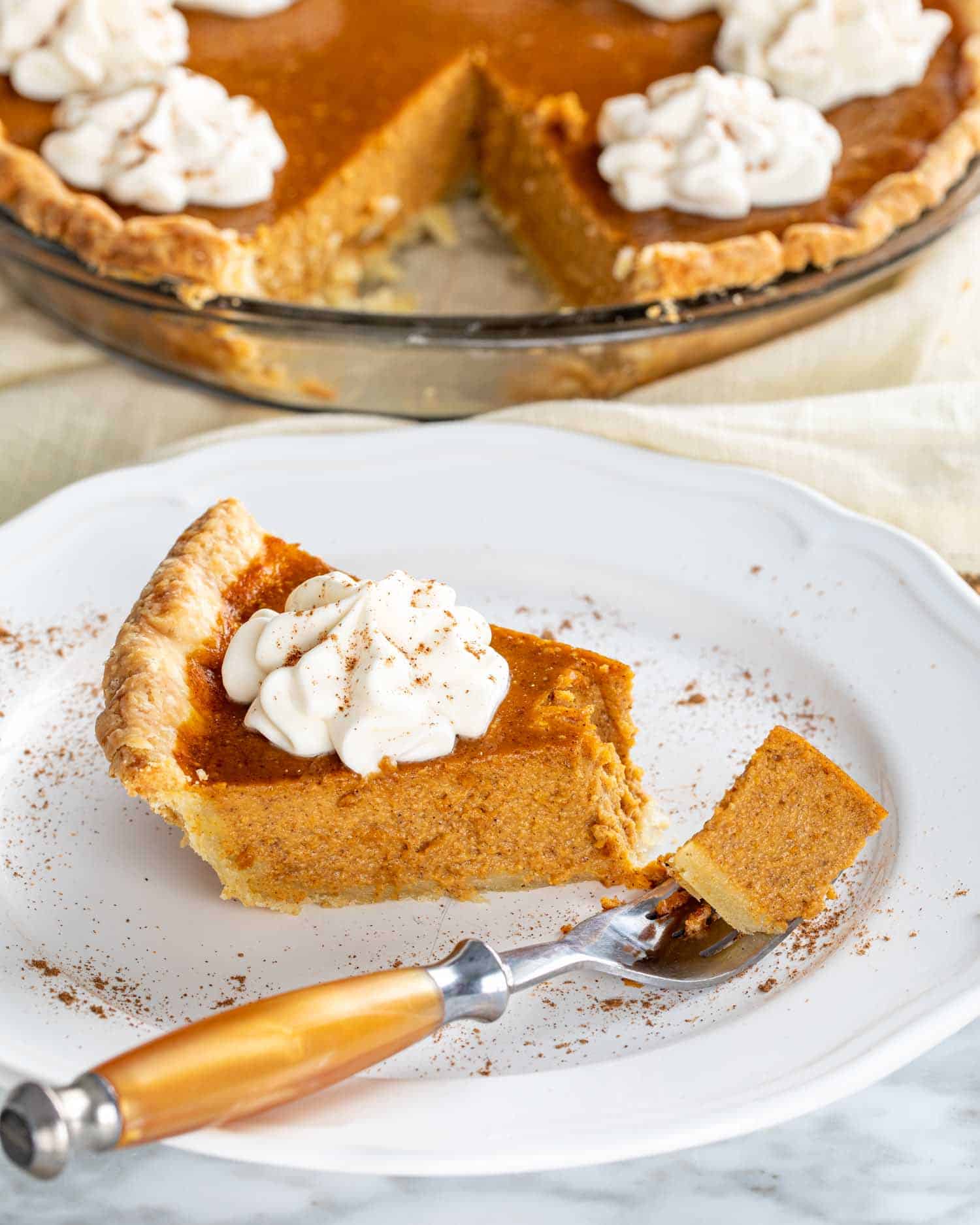 a slice of pumpkin pie on a white plate.