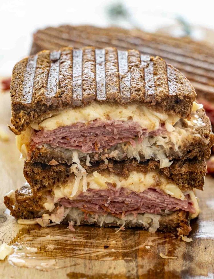 A reuben sandwich cut in half and stacked with the centers exposed.