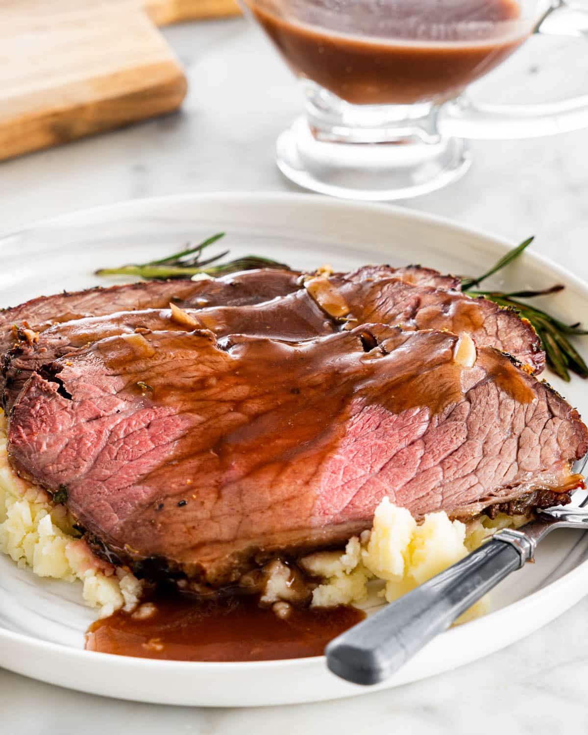 3 slices of roast beef over a bed of mashed potatoes topped with gravy