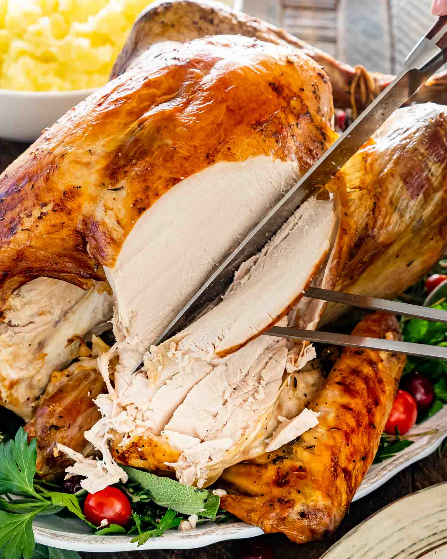 a hand carving turkey breast from a roast turkey.