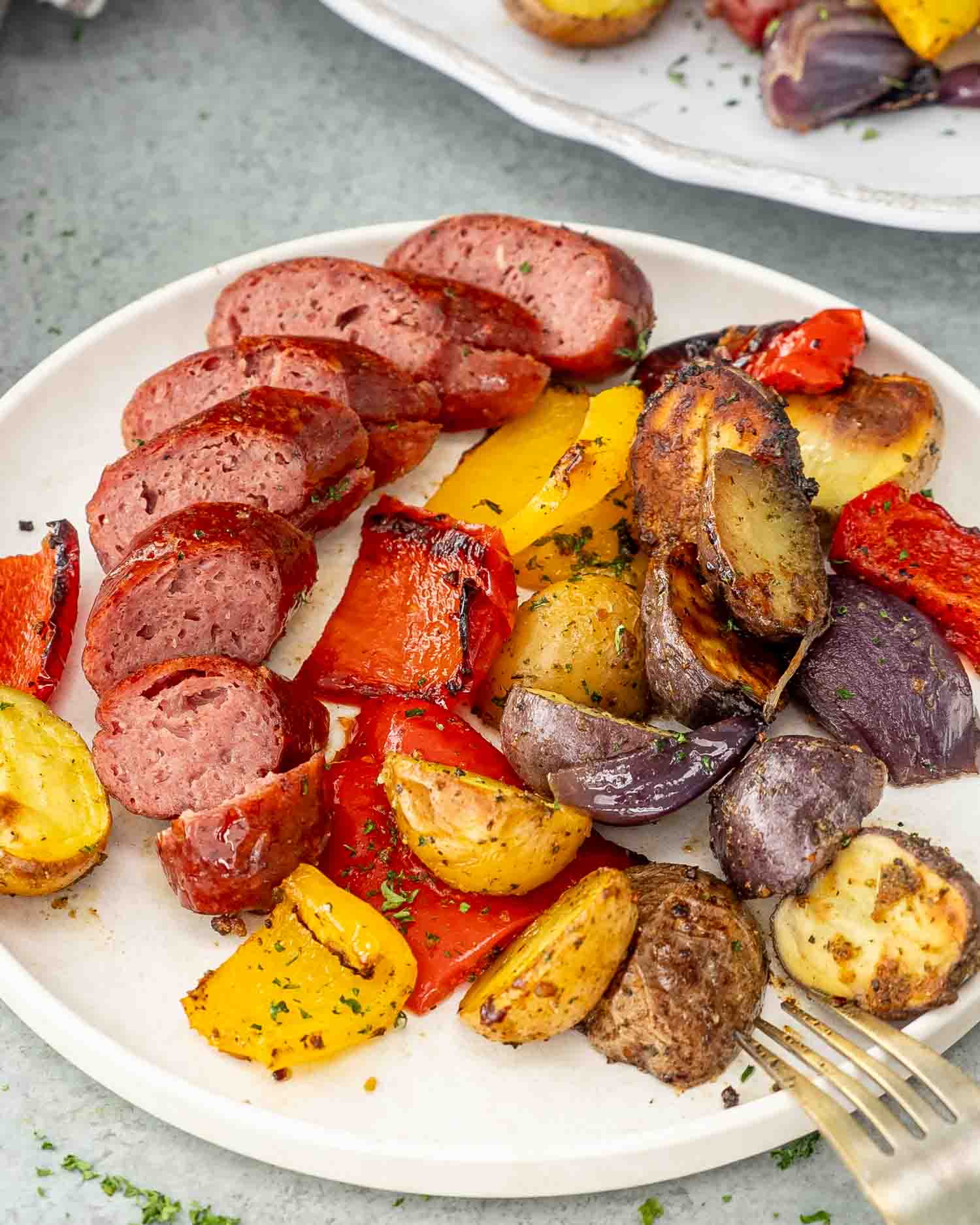 a plate full of sausage and potato sheet pan dinner.