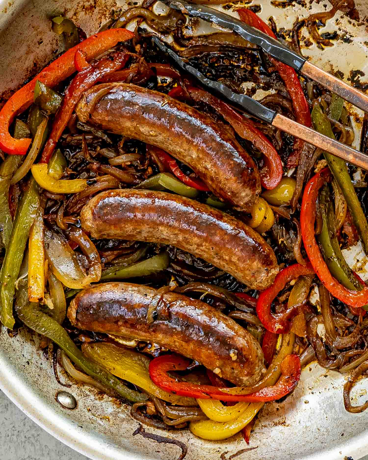sausage peppers and onions in a skillet.