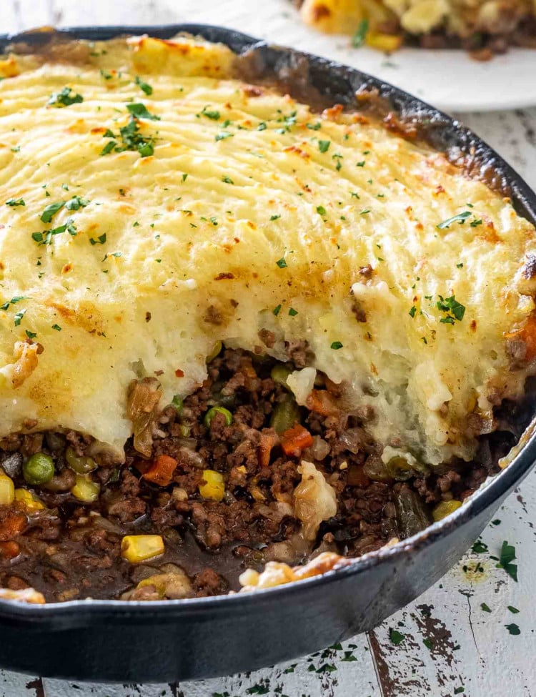 skillet shepherd's pie in a cast iron skillet with a portion taken out.