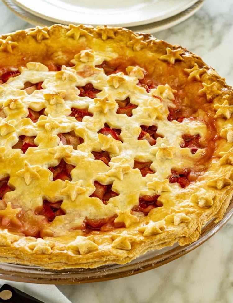 side view shot of strawberry rhubarb pie with star cut outs.