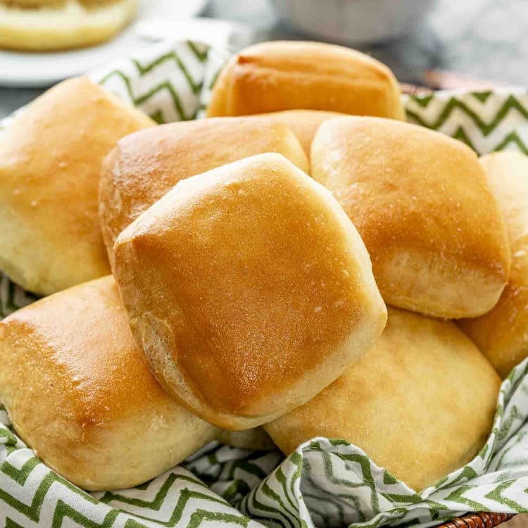 side view shot of a basket full of texas roadhouse rolls.