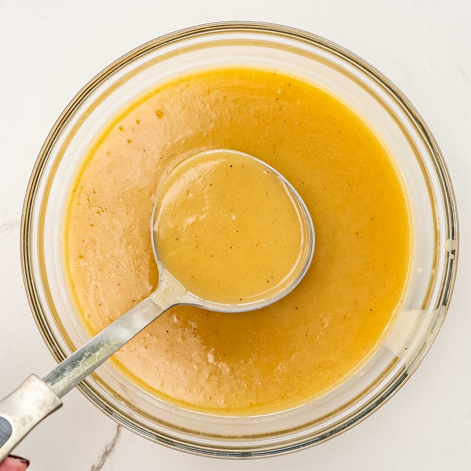 a bowl with a ladle with freshly made turkey gravy.